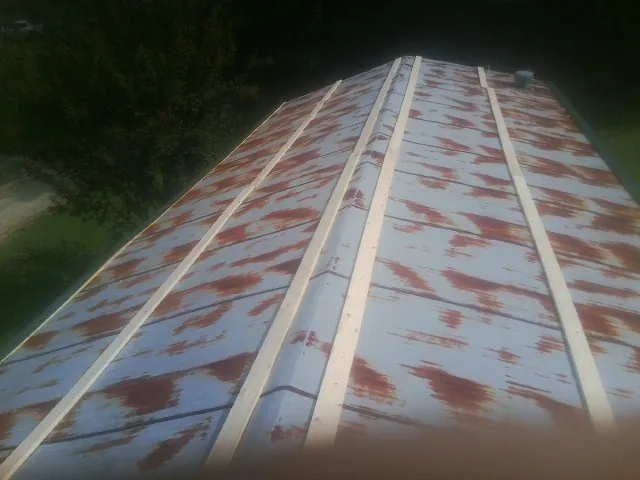 Rusted metal roof panels with new wood purlins before replacement — Storm Damage Roof Repair in Williamston by Roofing Brothers
